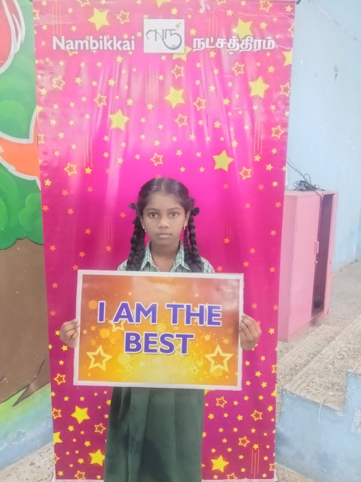A student holding an ‘I am the best’ sign at a Nambikkai Nakshathram session